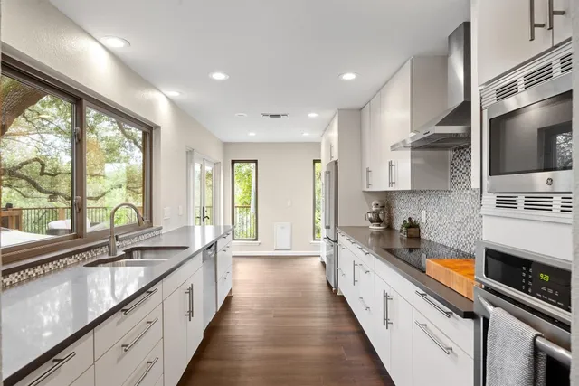 a large kitchen with stainless steel appliances granite countertop a lot of counter space and a sink