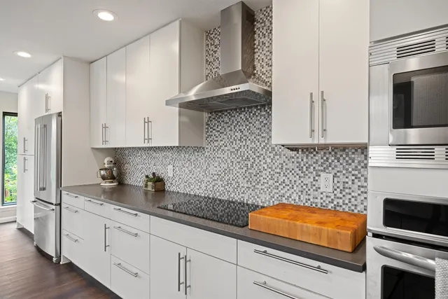 a kitchen with stainless steel appliances granite countertop a sink a stove and a refrigerator