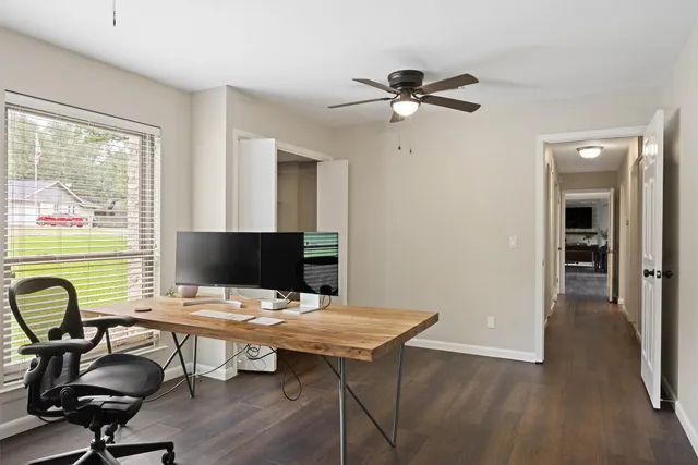 a view of a workspace with furniture and a window