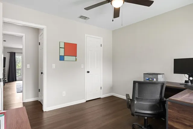 a view of workspace with wooden floor ceiling fan and windows