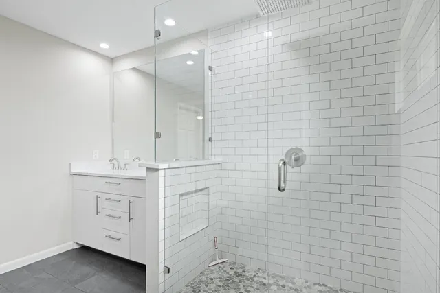 a bathroom with a double vanity sink a shower and a mirror