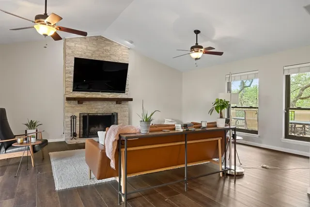 a living room with furniture a fireplace and a flat screen tv