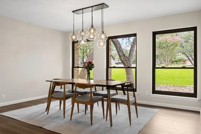 a view of a dining room with furniture a chandelier and wooden floor