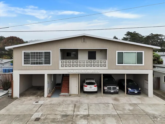 a view of a house with a balcony and car parked