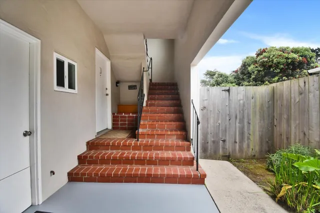 a view of a balcony with furniture and front door