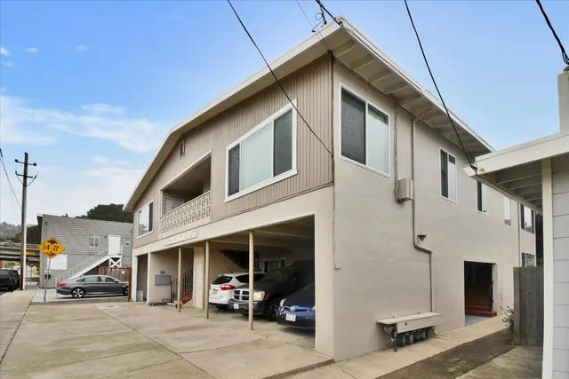 a view of a house with a patio and a yard