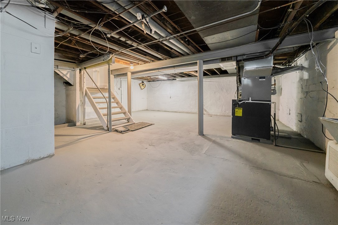 1391 Avondale Road Cleveland, OH 44121 - Photo 40 of 46 Unfinished below grade area featuring heating unit and stairway