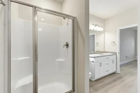 a bathroom with a granite countertop shower sink and mirror