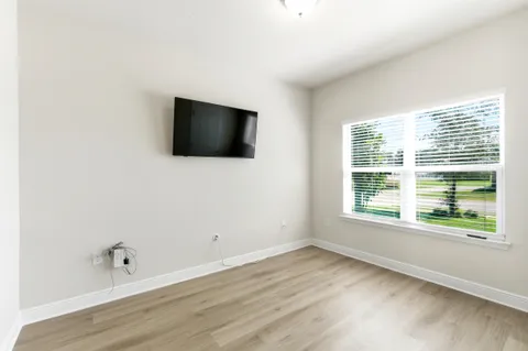 a flat screen tv on a dresser next to a window