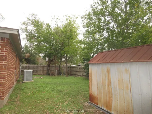 a view of a backyard with a garden and trees