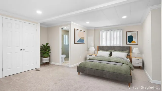 a bedroom with a large bed and a potted plant