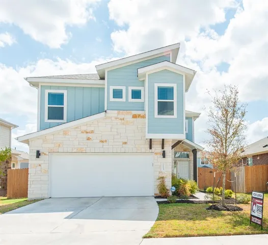 a white house that has tree in front of it