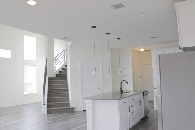 a kitchen with a sink cabinets and wooden floor