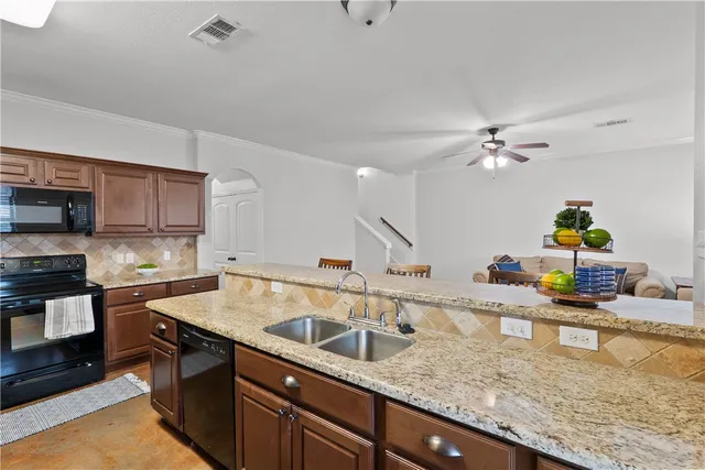 a kitchen with stainless steel appliances granite countertop a sink a stove counter space and cabinets