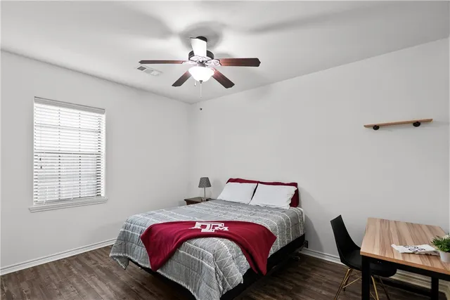 a bedroom with a bed and wooden floor