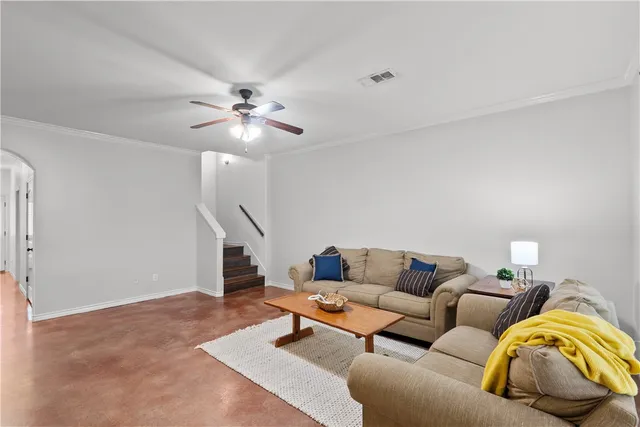 a living room with furniture and a ceiling fan