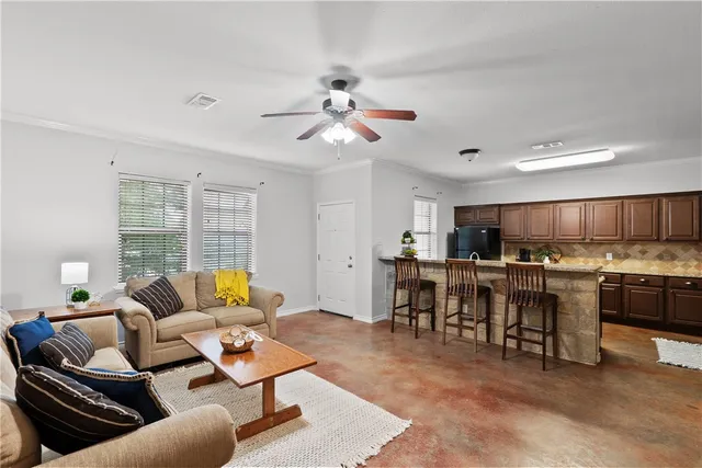 a living room with lots of furniture and kitchen view