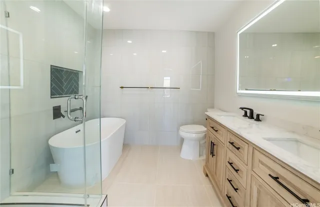 a spacious bathroom with a double vanity sink a toilet a shower and a mirror