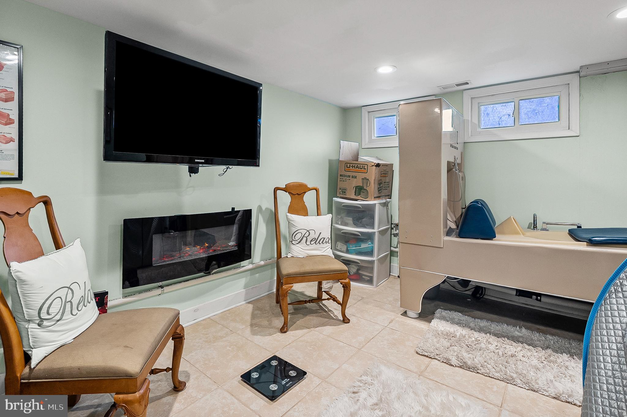 1229 Winston Avenue Baltimore, MD 21239 - Photo 15 of 19 a living room with furniture a flat screen tv and a fireplace