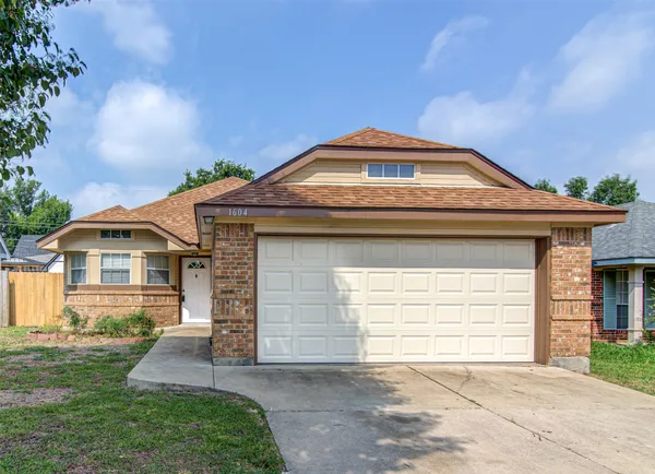 a front view of a house with a garden and garage