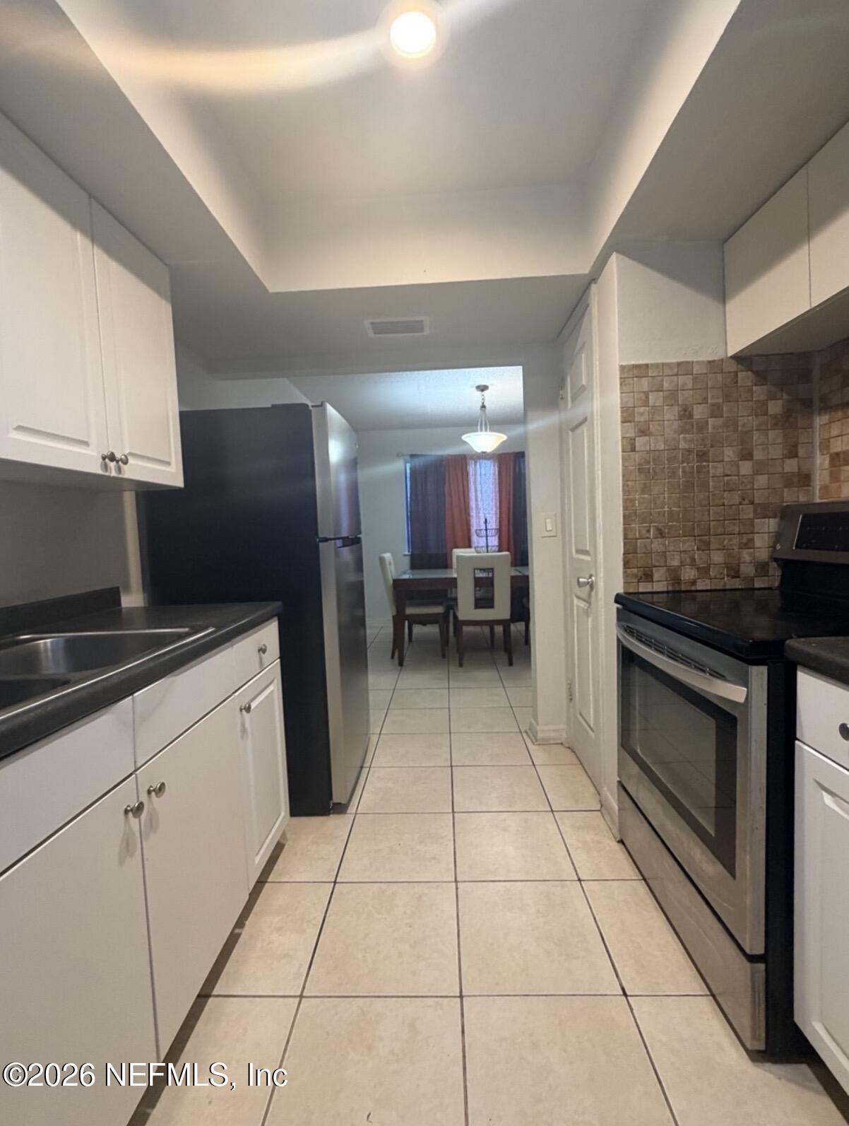 710 Oaks Plantation Drive, Unit R12 Jacksonville, FL 32211 - Photo 2 of 2 a kitchen with granite countertop a sink cabinets and stainless steel appliances