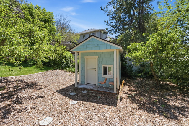 1683 North Main Street Centerville, UT 84014 - Photo 33 of 37 Light blue shingle-sided shed with a white trim and a small porch