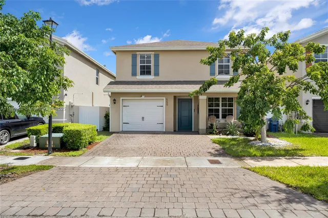 a front view of a house with a yard and a garage