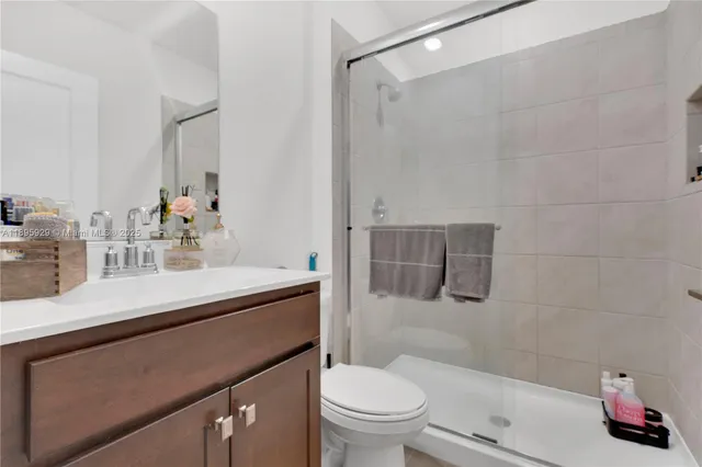 a bathroom with a sink toilet vanity and shower
