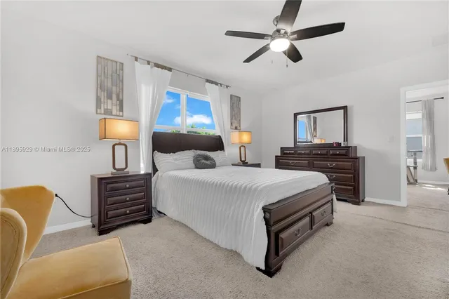 a bedroom with a bed a chandelier and dresser