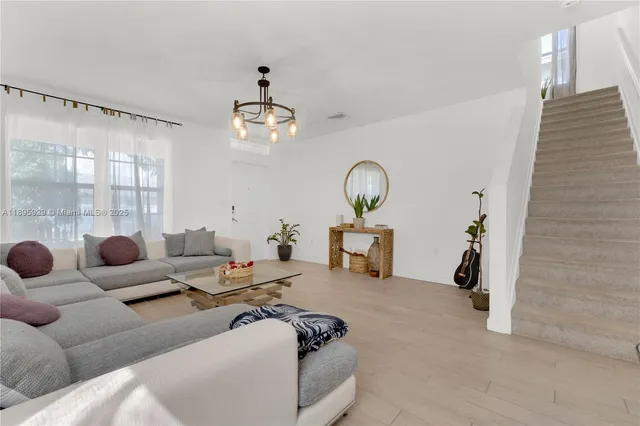 a living room with furniture and a chandelier