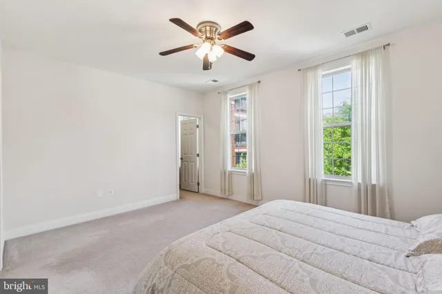 a bedroom with a large bed window and a chandelier
