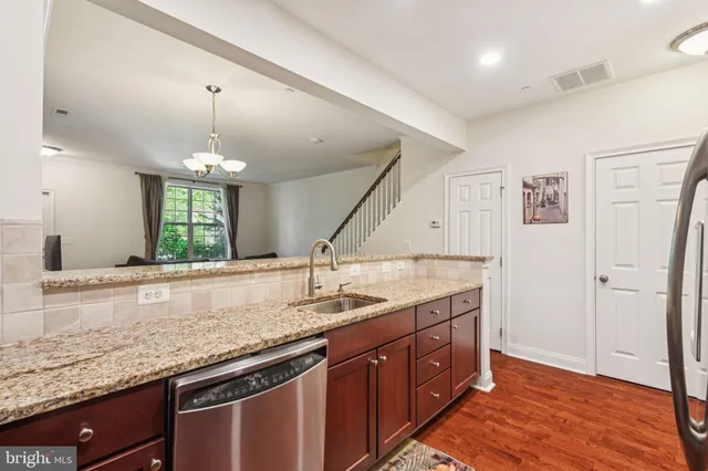 a bathroom with a granite countertop sink and a large mirror