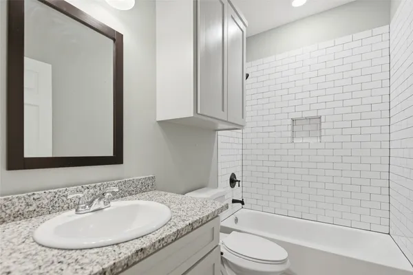 a bathroom with a granite countertop sink toilet and shower