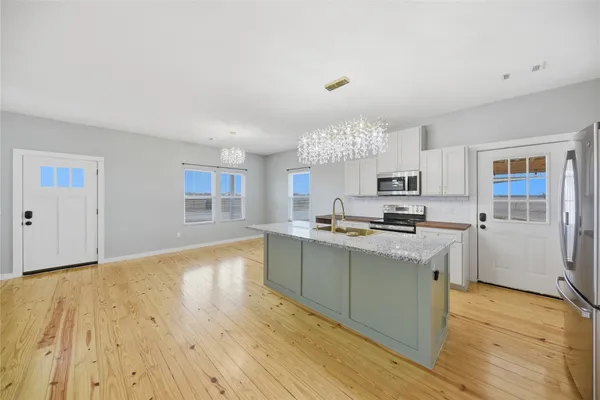 a kitchen with granite countertop a sink cabinets and wooden floor