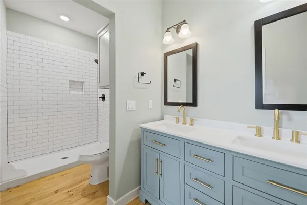 a bathroom with a toilet a sink a shower and a mirror