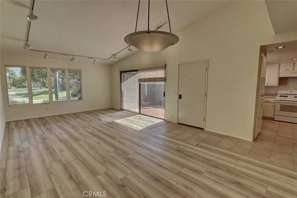 8566 Larkhall Circle, Unit 808A Huntington Beach, CA 92646 - Photo 11 of 46 a view of an empty room with wooden floor and a window