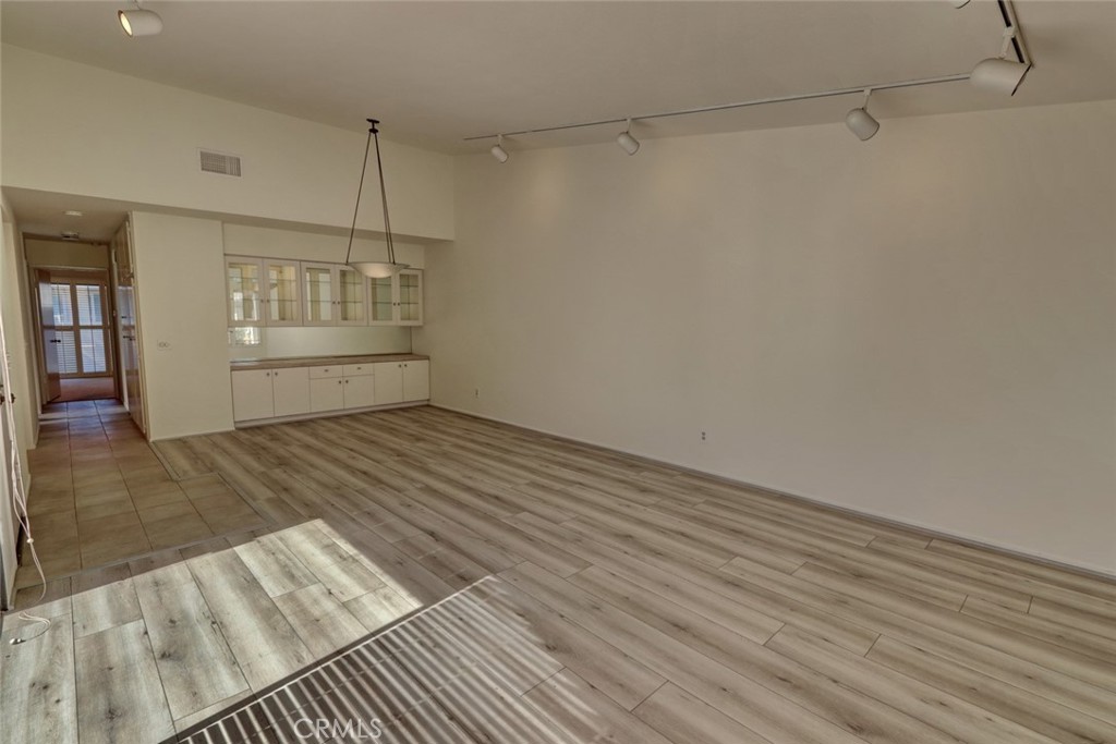 8566 Larkhall Circle, Unit 808A Huntington Beach, CA 92646 - Photo 12 of 46 a view of an empty room with wooden floor and a window