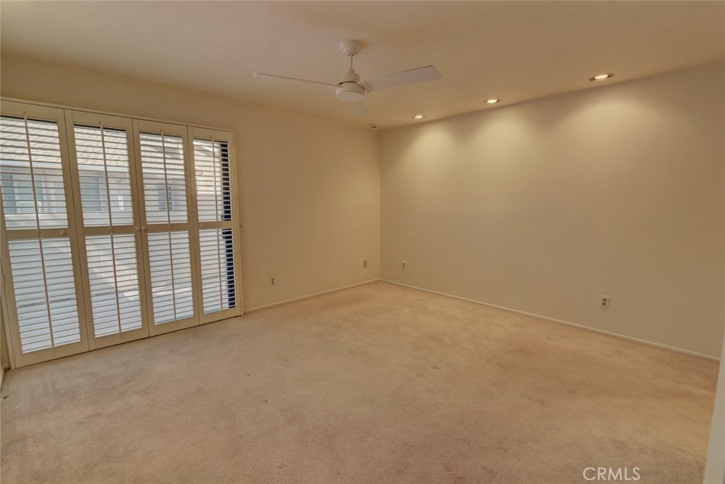 8566 Larkhall Circle, Unit 808A Huntington Beach, CA 92646 - Photo 16 of 46 en empty room with windows and ceiling fan