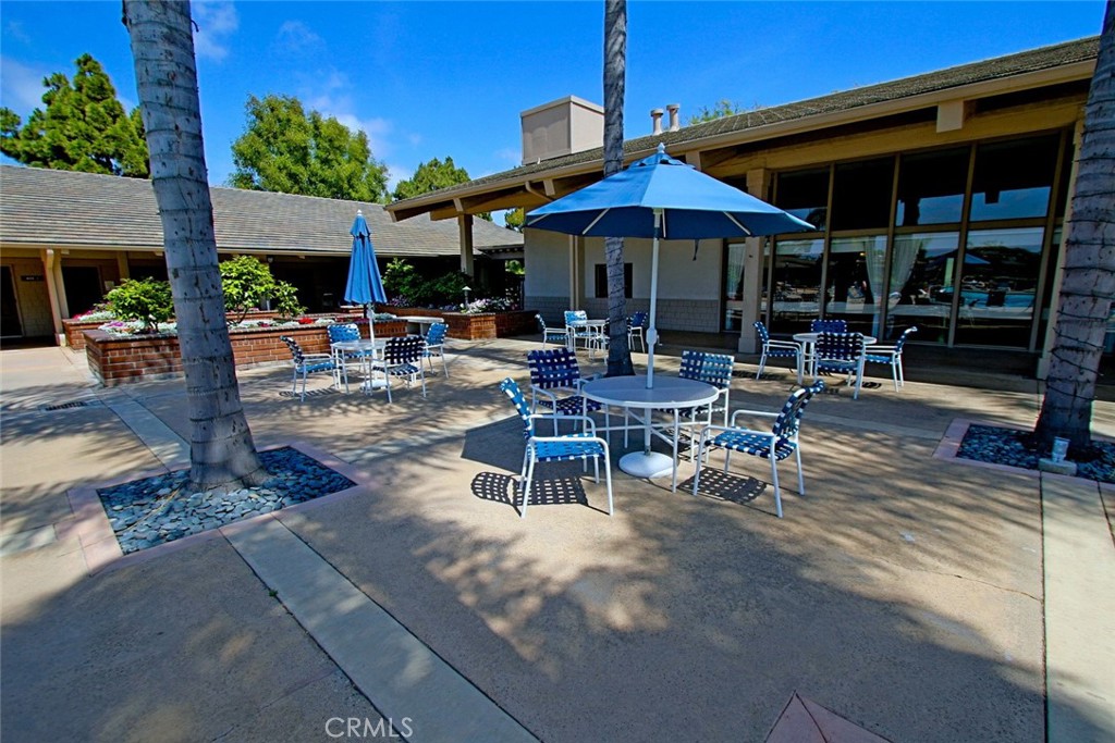 8566 Larkhall Circle, Unit 808A Huntington Beach, CA 92646 - Photo 36 of 46 a view of patio with chairs and tables under an umbrella
