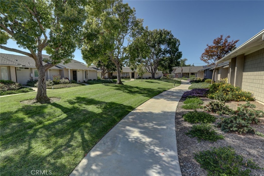 8566 Larkhall Circle, Unit 808A Huntington Beach, CA 92646 - Photo 5 of 46 a front view of a house with a yard and tree