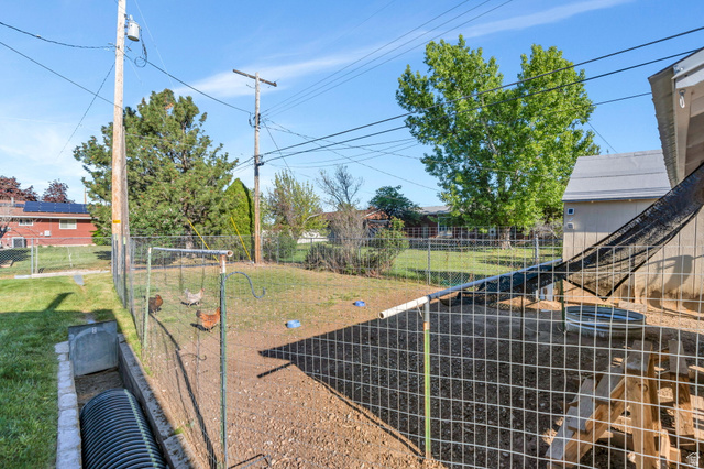 377 North 650 East, Unit 9 Orem, UT 84097 - Photo 5 of 9 Fenced yard space featuring a detached shed, a sloped drainage pipe, and mature trees