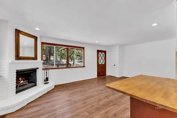 a view of empty room with wooden floor and fireplace