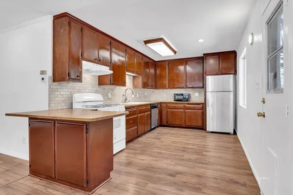 a kitchen with kitchen island granite countertop wooden cabinets stainless steel appliances a sink and a counter top space