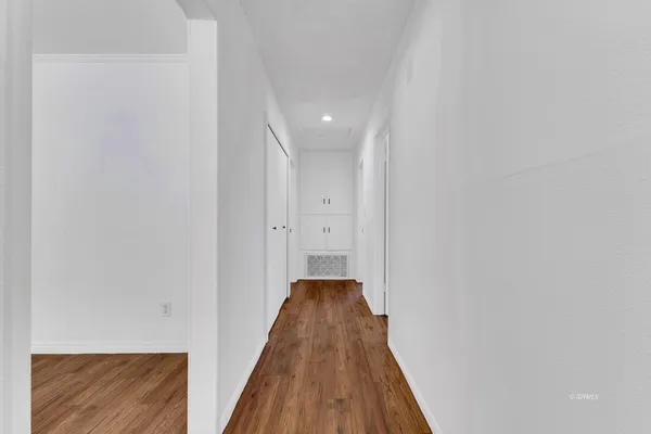 a view of a hallway with wooden floor and staircase