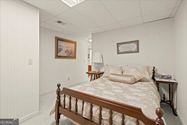 a bedroom with a bed and a painting on the wall