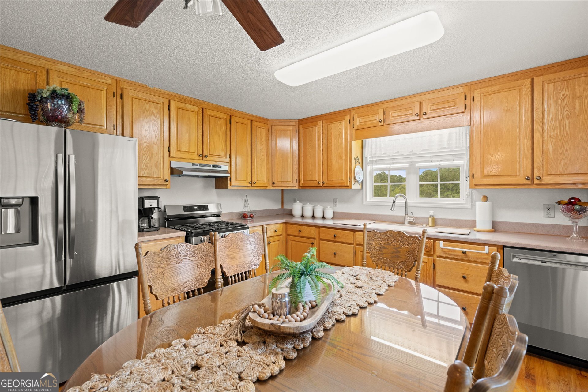 2643 Macedonia Road Franklin, GA 30217 - Photo 3 of 47 a kitchen with stainless steel appliances granite countertop a refrigerator a sink dishwasher a dining table and chairs with wooden floor
