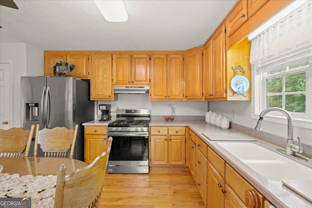 a kitchen with stainless steel appliances granite countertop a sink stove and refrigerator