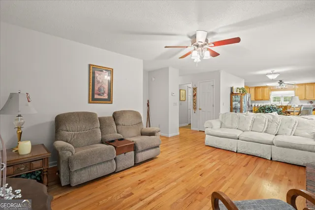 a living room with furniture kitchen view and a chandelier