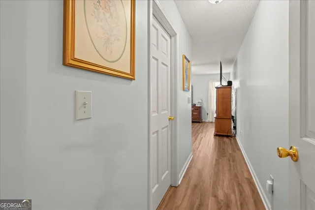 a view of a hallway with wooden floor and closet