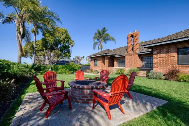 a view of a chairs and table in patio with a fire pit